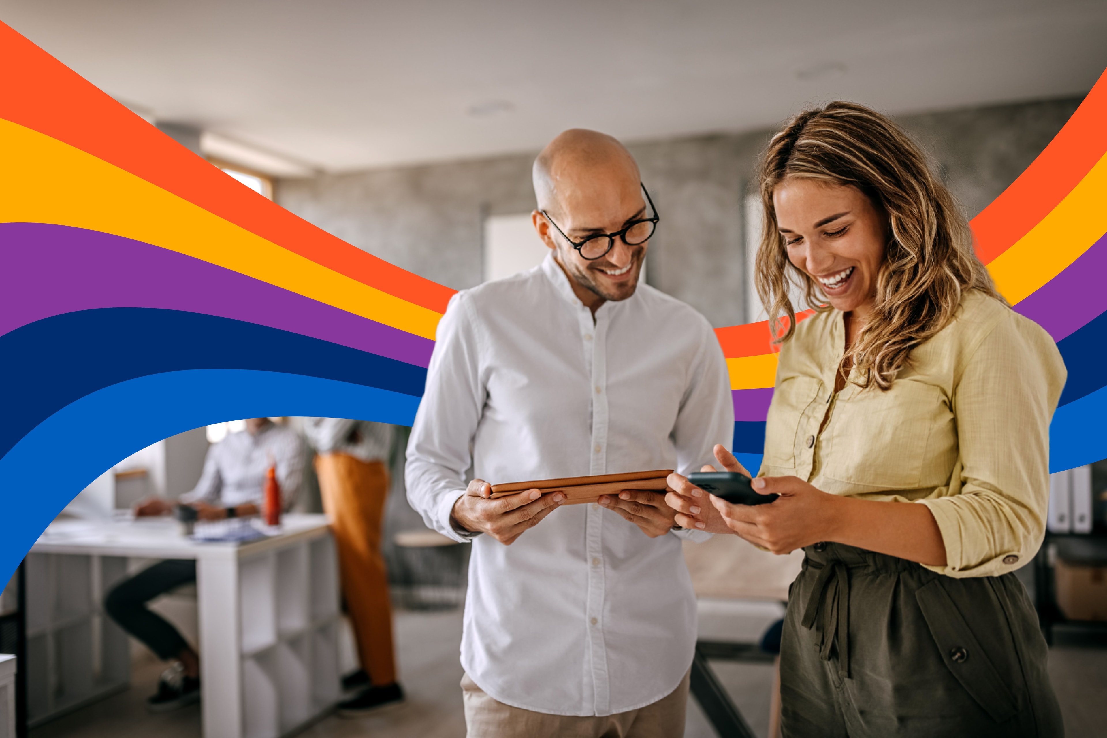 a man and a woman are looking at a tablet and a cell phone .