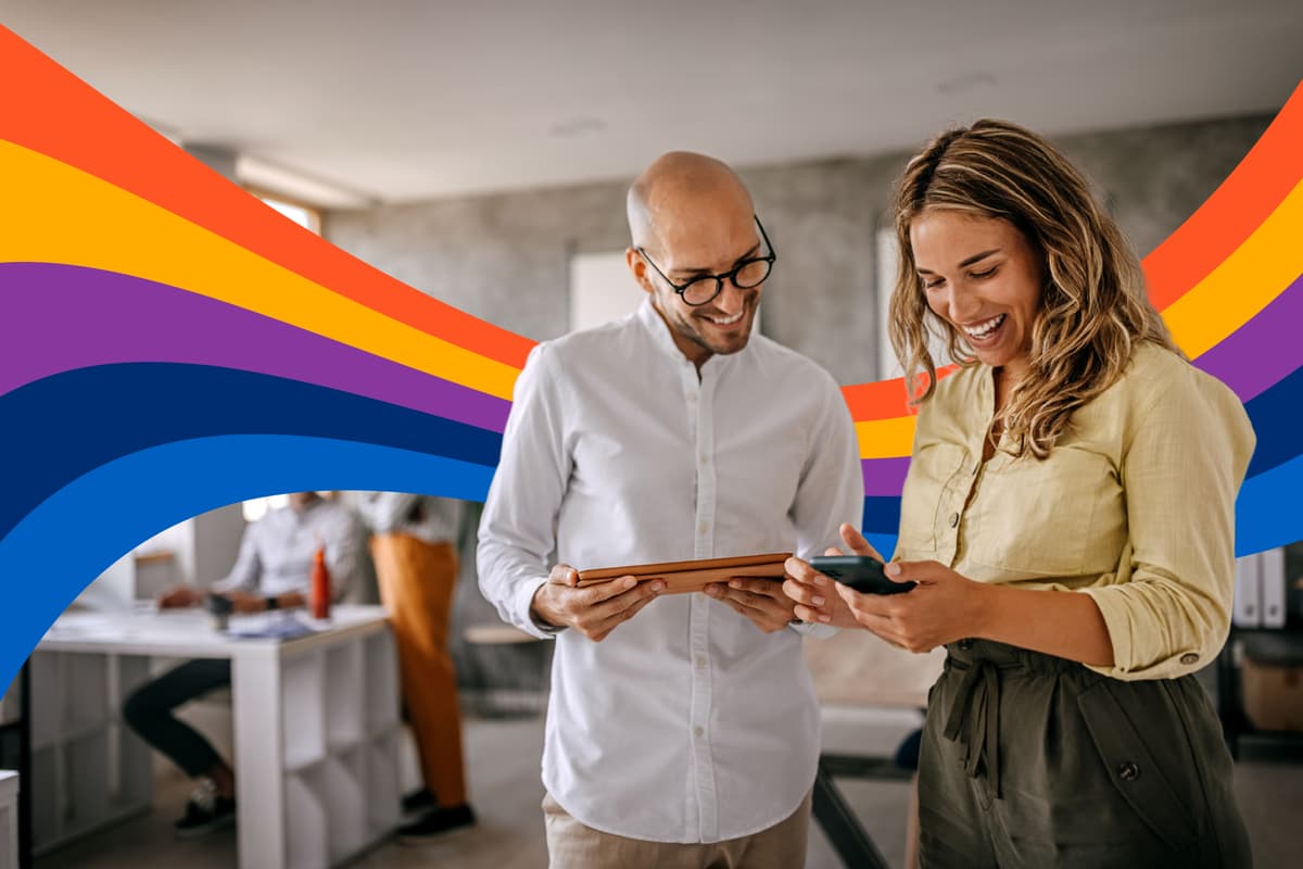 a man and a woman are looking at a tablet and a cell phone .