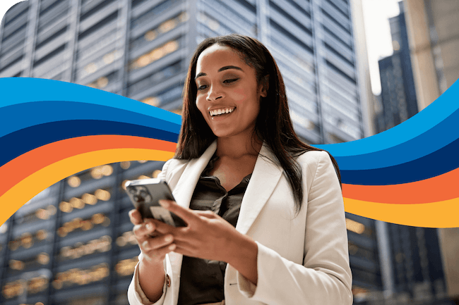 a woman is smiling while looking at her phone