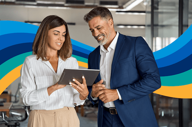 a man and a woman are looking at a tablet together